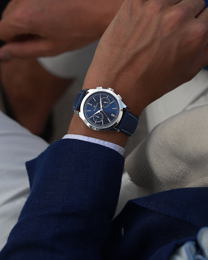 A round mens watch in rhodium-plated silver from Waldor & Co. with blue sunray dial and genuine blue leather strap. A second hand. Seiko movement. The model is Chrono 39 Sardinia 39mm.