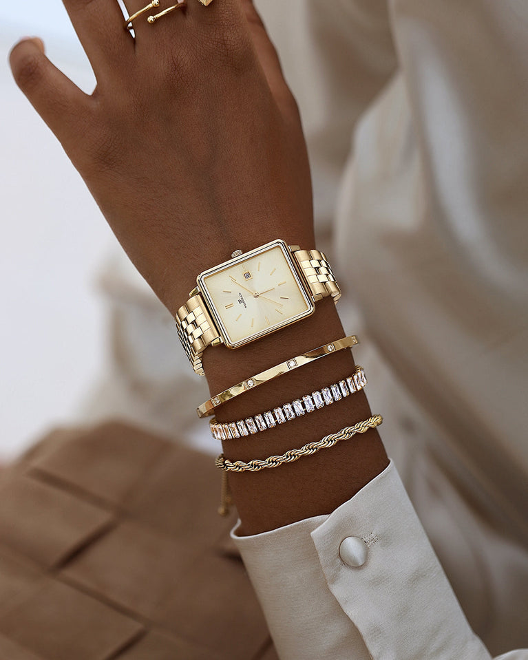  A square womens watch in gold from Waldor & Co. with silver sunray dial and a second hand. Seiko movement. The model is Delight 32 Chelsea 28x32mm.