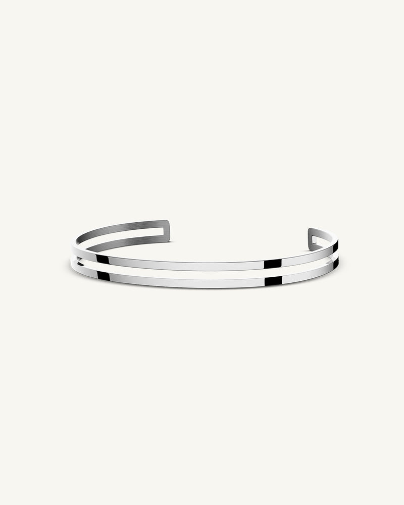A Bangle in polished silver 316L stainless steel from Waldor & Co. One size. The model is Dual Bangle Polished.