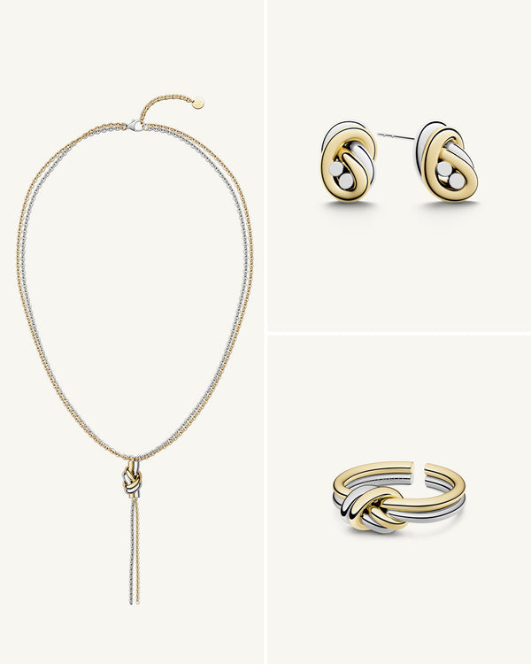 A polished stainless steel jewelry set in 14k gold from Waldor & Co. One size. The model is Dual Knot Ring.