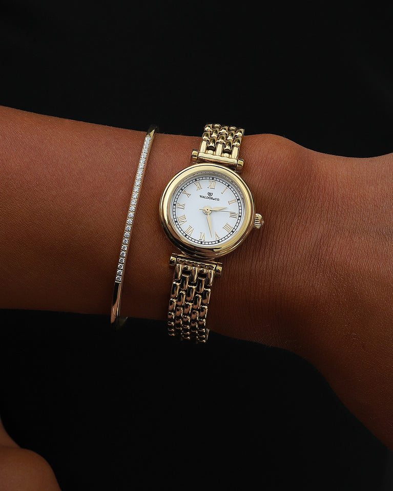  A round womens watch in 22k gold plated 316L stainless steel from Waldor & Co. with white Sapphire Crystal glass dial. Seiko movement. The model is Venia 24 Villefranche.