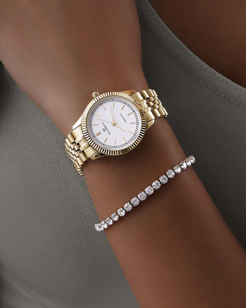 A round womens watch in 14k gold from Waldor & Co. with white sunray dial and a second hand. Seiko movement. The model is Imperial 32 Positano 32mm.