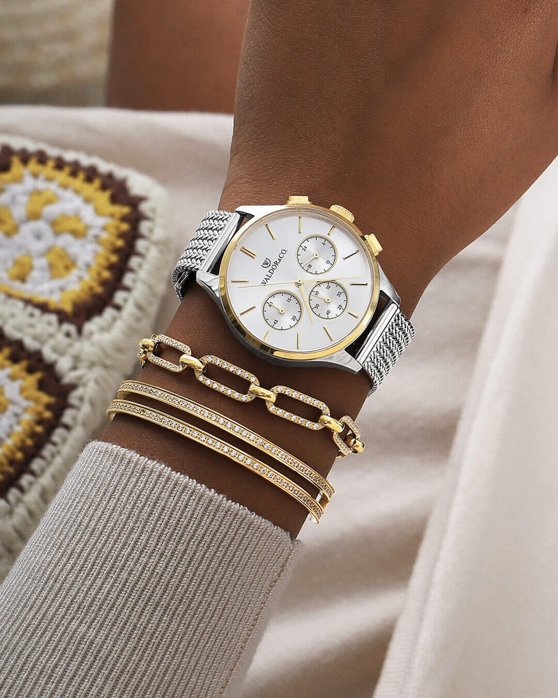 A round womens watch in silver and 14k gold from Waldor & Co. with silver dial and a second hand. Seiko movement. The model is Epoch 36 Formentera 36mm.