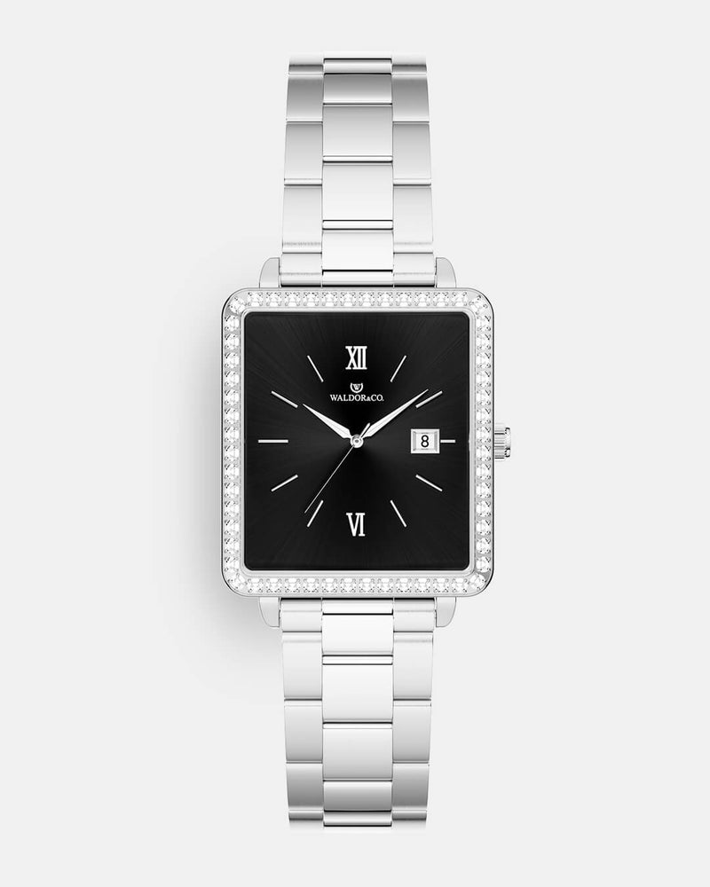 A square womens watch in silver with stones from WALDOR & CO. with black sunray dial and a second hand. Seiko VJ22 movement. The model is Delight 32 Mayfair 28x32mm. 